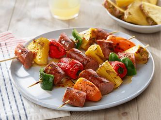 Glazed Sausage & Pineapple Kabobs on a white plate.