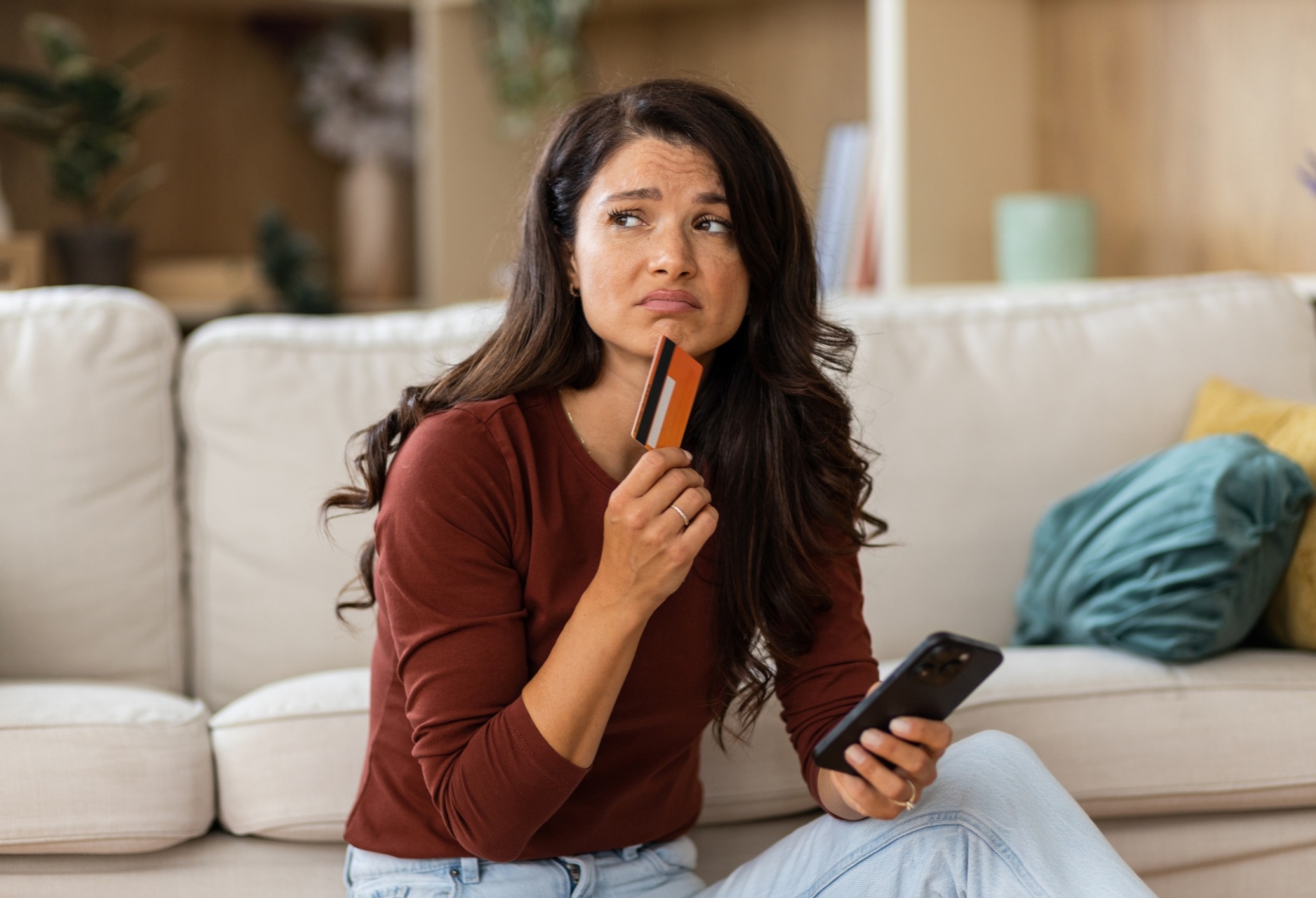 Woman thinking about purchasing using a credit card
