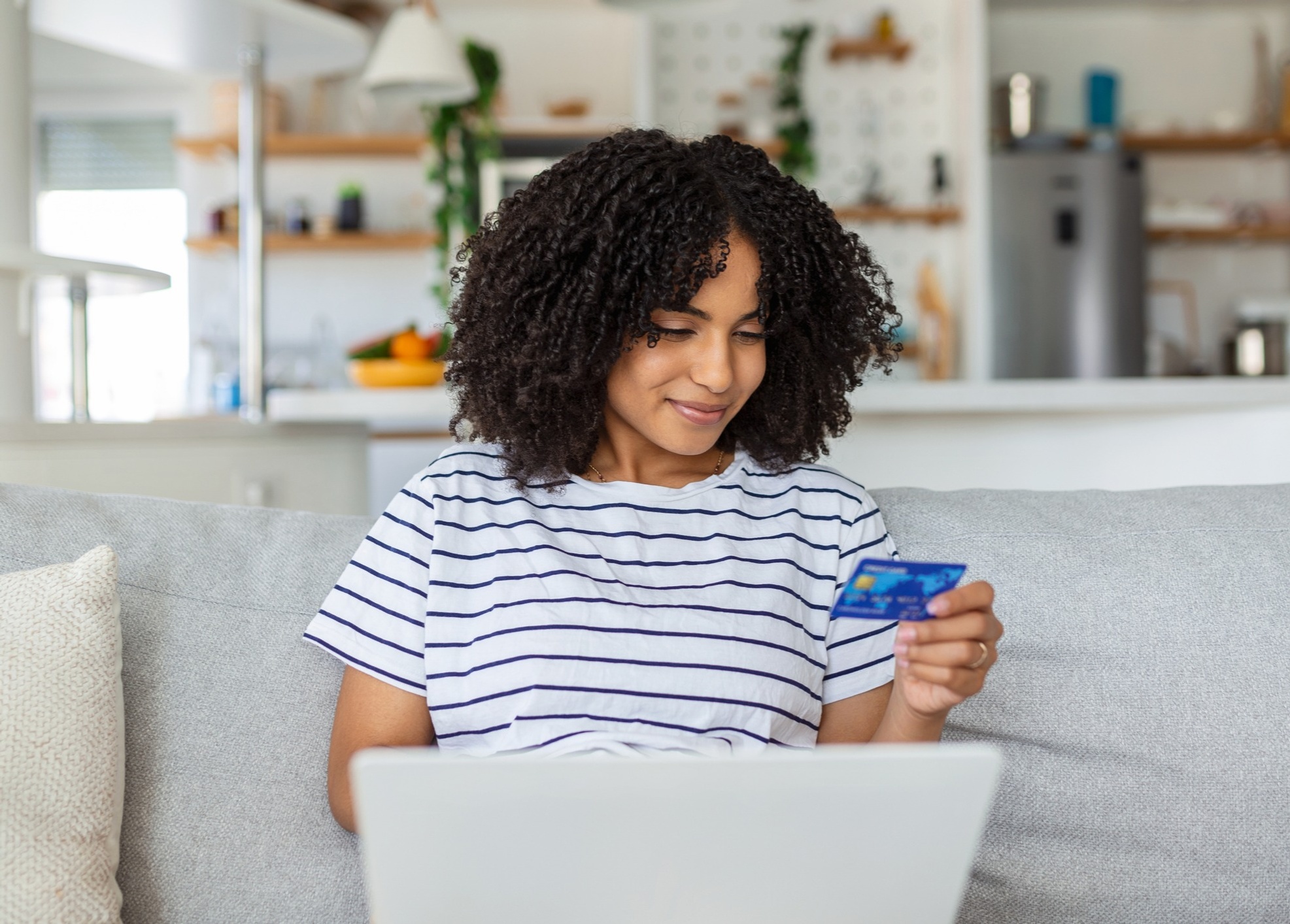 Woman looking at credit card on laptop