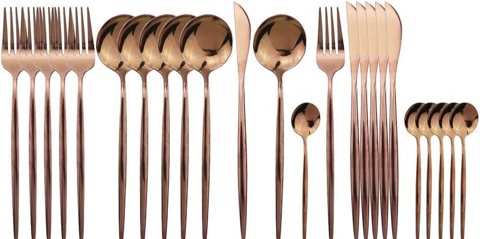 A row of rose gold forks, spoons and knives