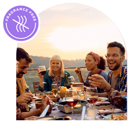 People gathered around a table eating and drinking at sunset
