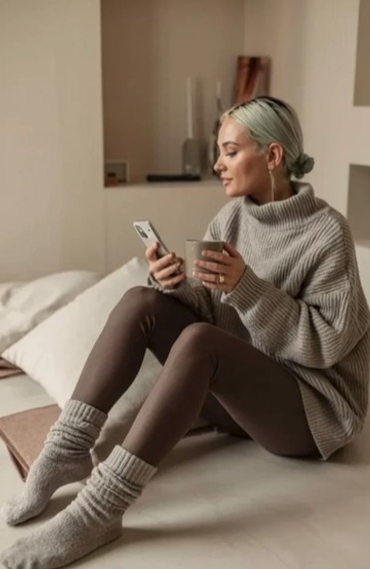 Woman in cozy grey sweater and socks