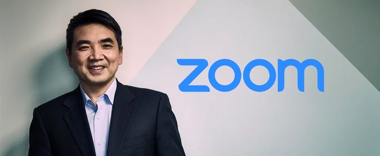 A studio portrait of Zoom founder Eric Yuan next to the blue Zoom company logo.