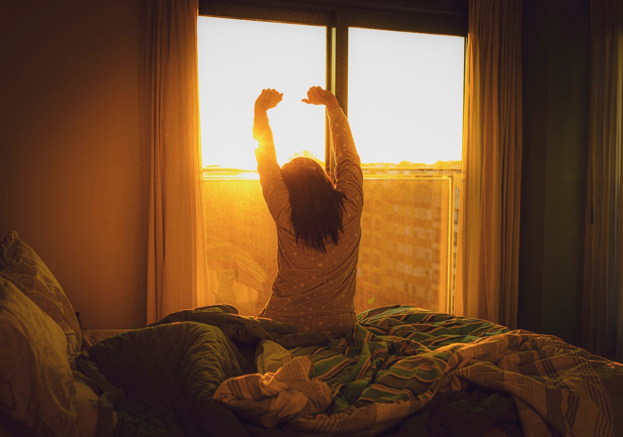 Woman waking up at sunrise