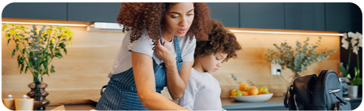 A mother and child packing a school lunch in a kitchen.