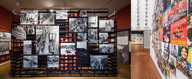 An interior view of a museum exhibition with historical black-and-white photos on grid displays and a colorful wall timeline on the right.