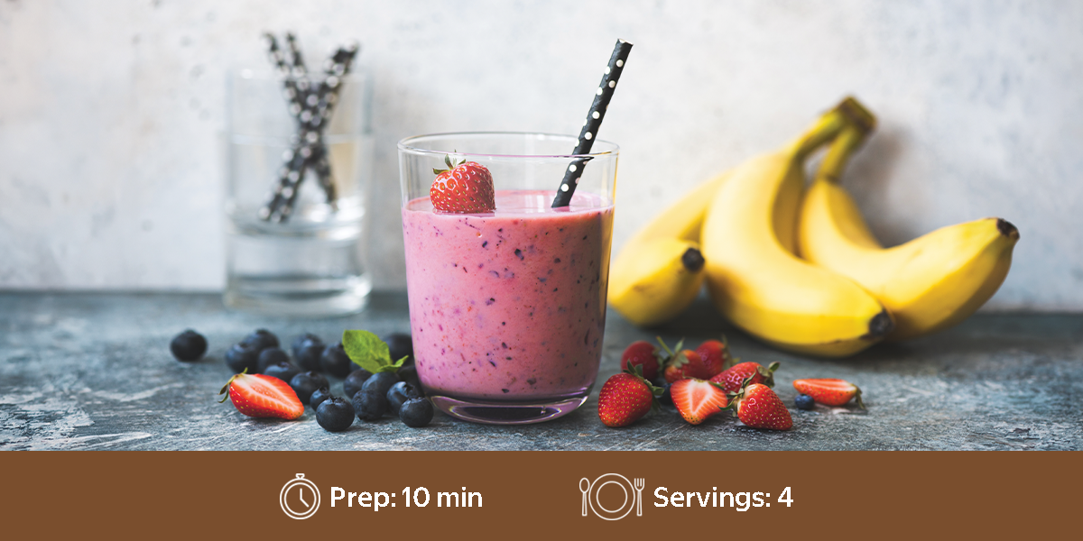 Strawberry and blueberry smoothie with bananas, topped with a strawberry and mint. Text at the bottom shows a preparation time of 10 minutes and 4 servings. / Batido de fresa y arándanos con plátanos, decorado con una fresa y menta. El texto en la parte inferior indica un tiempo de preparación de 10 minutos y 4 porciones.