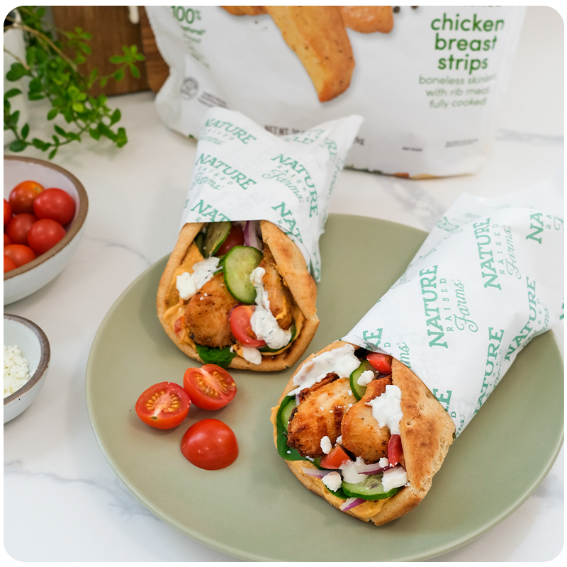 Nature Raised Farms chicken breast strips product shown with wrapped up loaded chicken wraps with fresh veggies and cheese